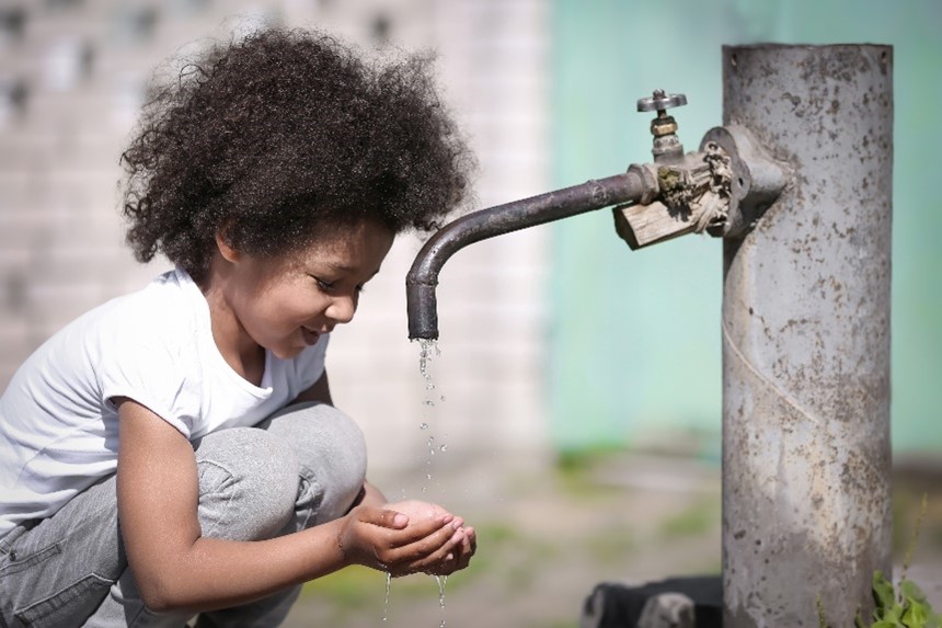 Kind met waterkraan